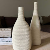 Two textured white vases on a wooden surface with a blurred background Rtfact