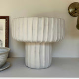 Marble-textured lamp on a shelf with a neutral background