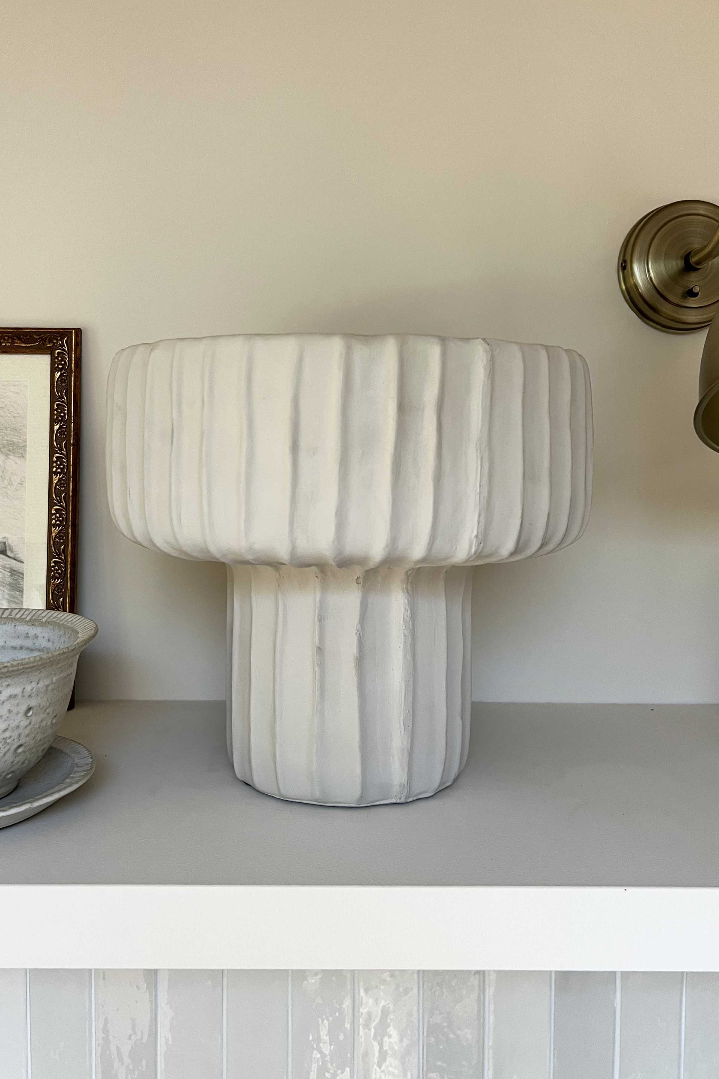 Marble-textured lamp on a shelf with a neutral background