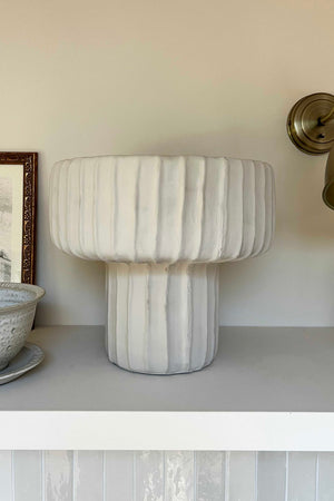Marble-textured lamp on a shelf with a neutral background