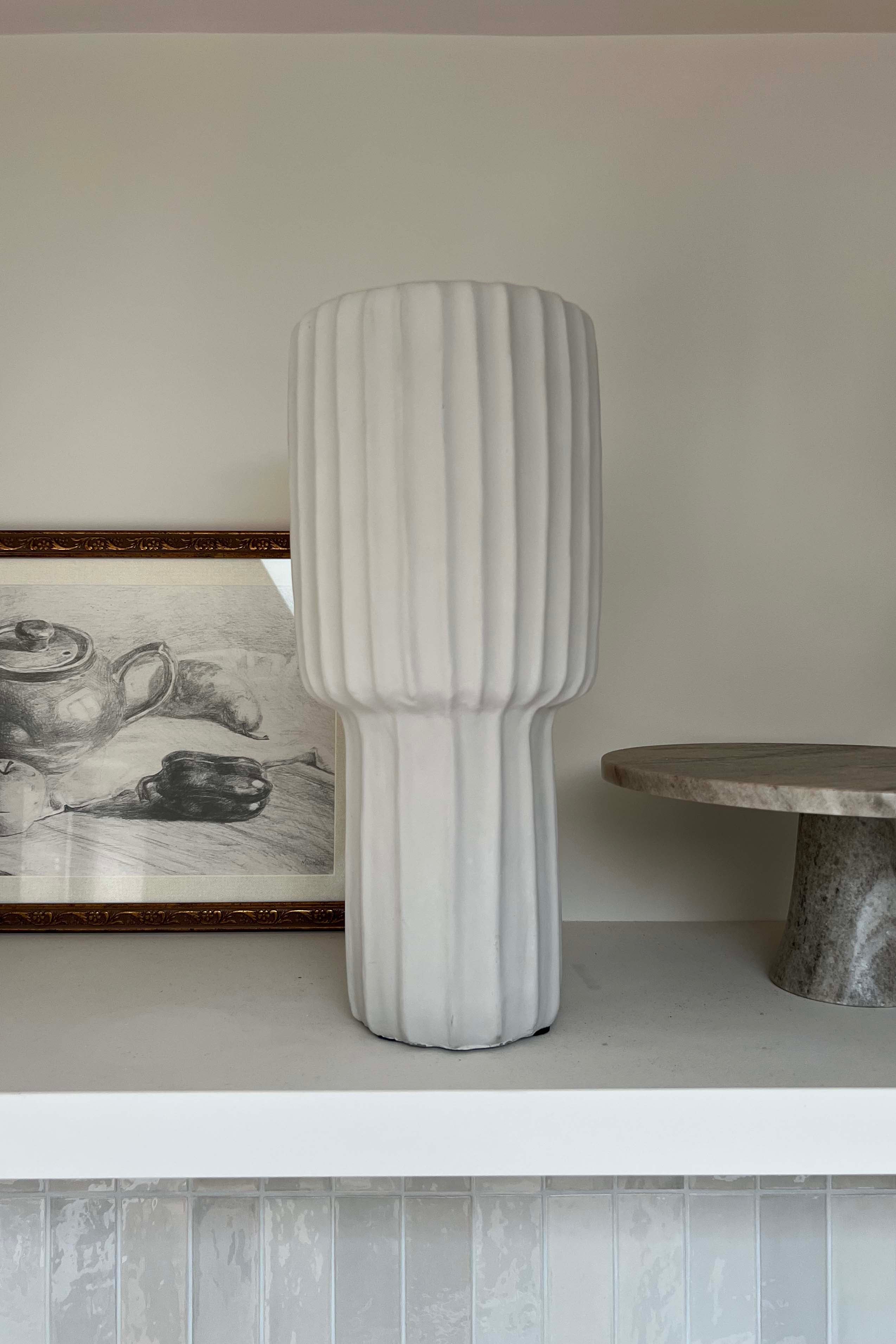 Textured vase on a shelf with a neutral background Rtfact