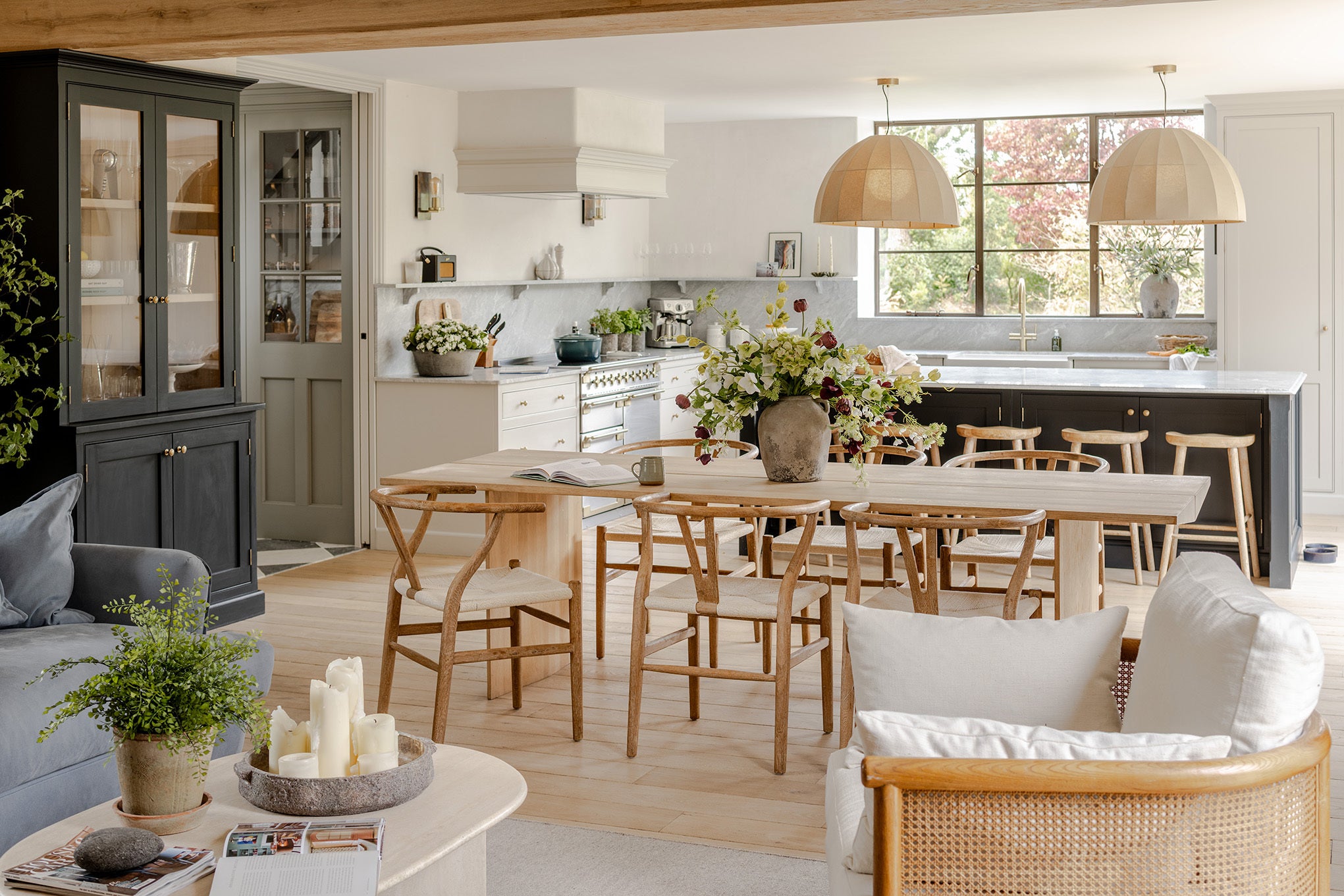 Modern kitchen and dining area with wooden furniture and decor.