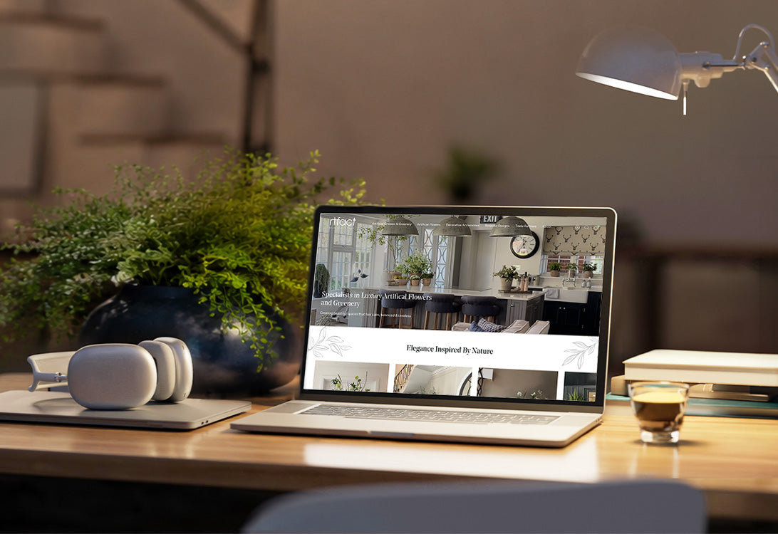 Laptop on a desk with a blurred background, displaying a website.