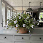 Faux Floral arrangement in a copper pot on a kitchen counter with reflective mirror wall. Rtfact