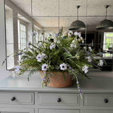 Faux Floral arrangement in a copper pot on a kitchen counter with reflective mirror wall. Rtfact