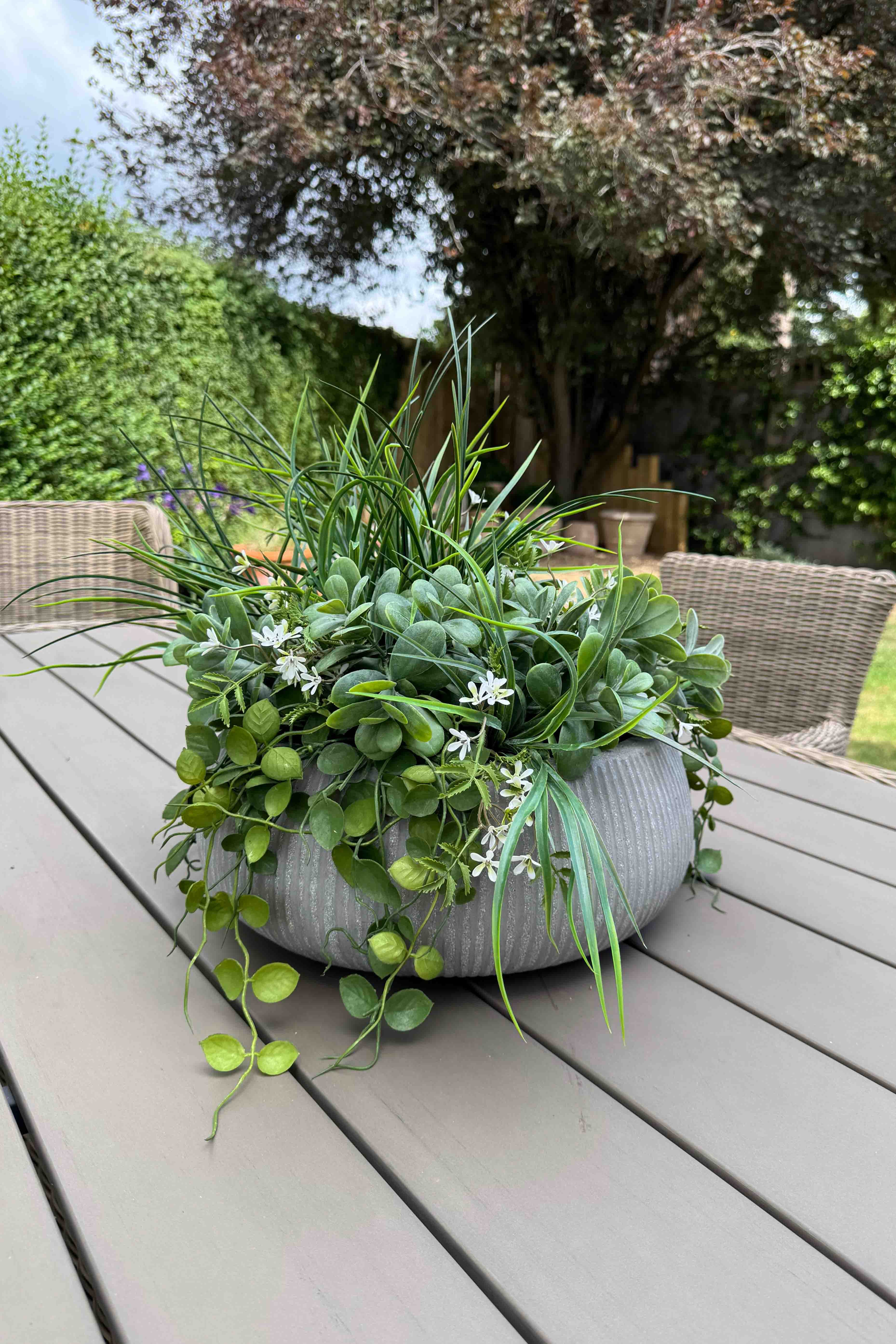 Faux Grasses, Greenery and Waxflower in a Ribbed Grey Bowl. UV resistant artificial greenery. Rtfact flowers