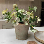 Faux bouquet plant on a kitchen counter with a wooden spoon and tray in the background
