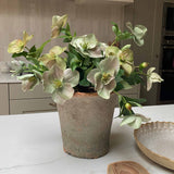 Faux bouquet plant on a kitchen counter with a wooden spoon and tray in the background