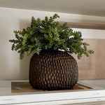 Decorative pot with faux green plant on a stack of books