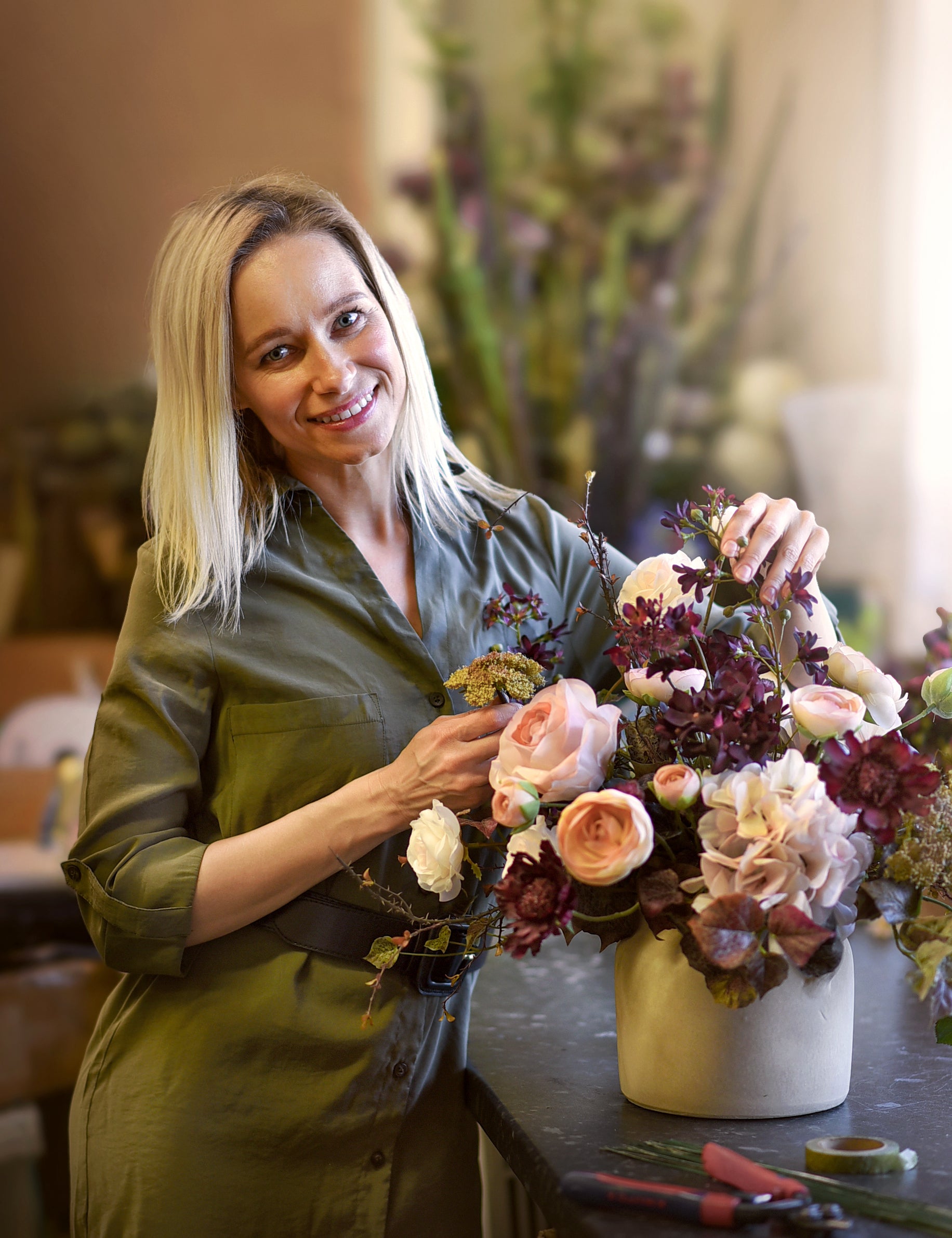 Woman holding a floral arrangement in a home setting