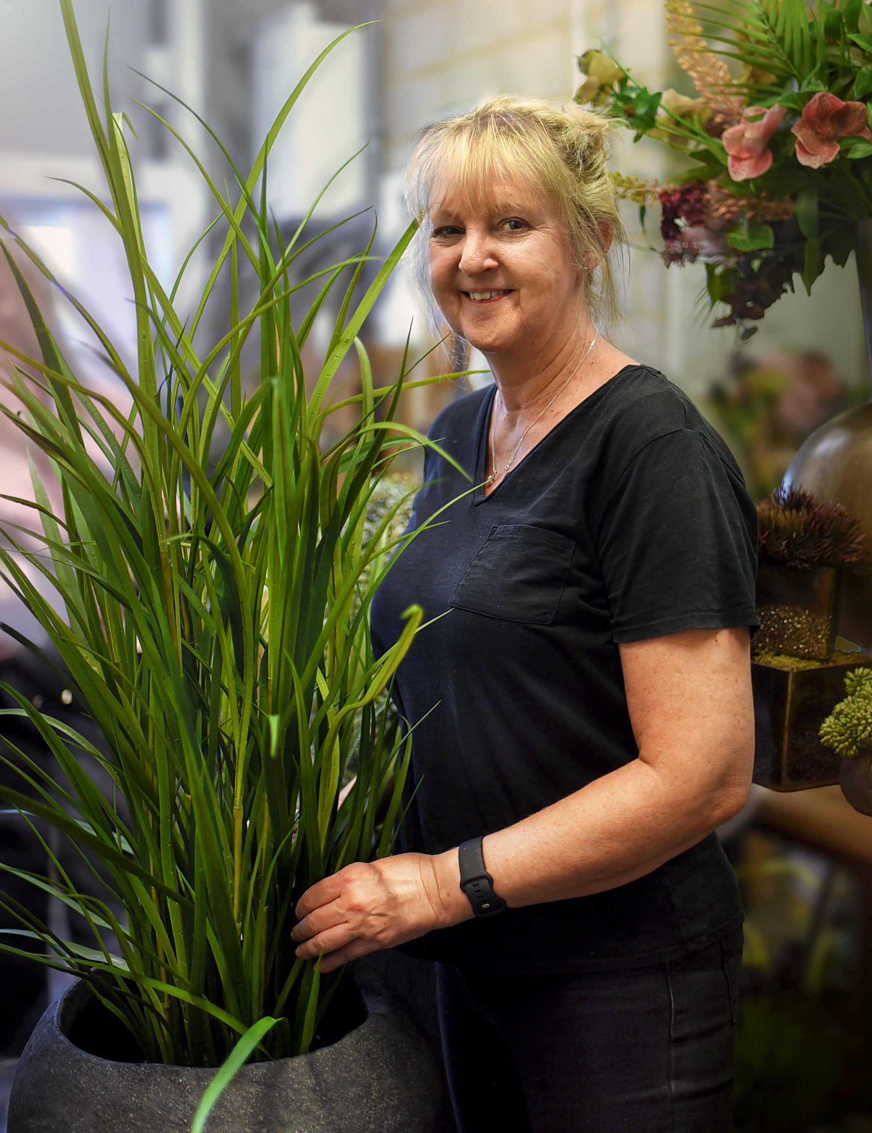 Woman holding a potted plant in an indoor setting