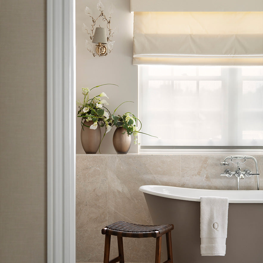 Bathroom interior with a bathtub, stool, and decorative elements.