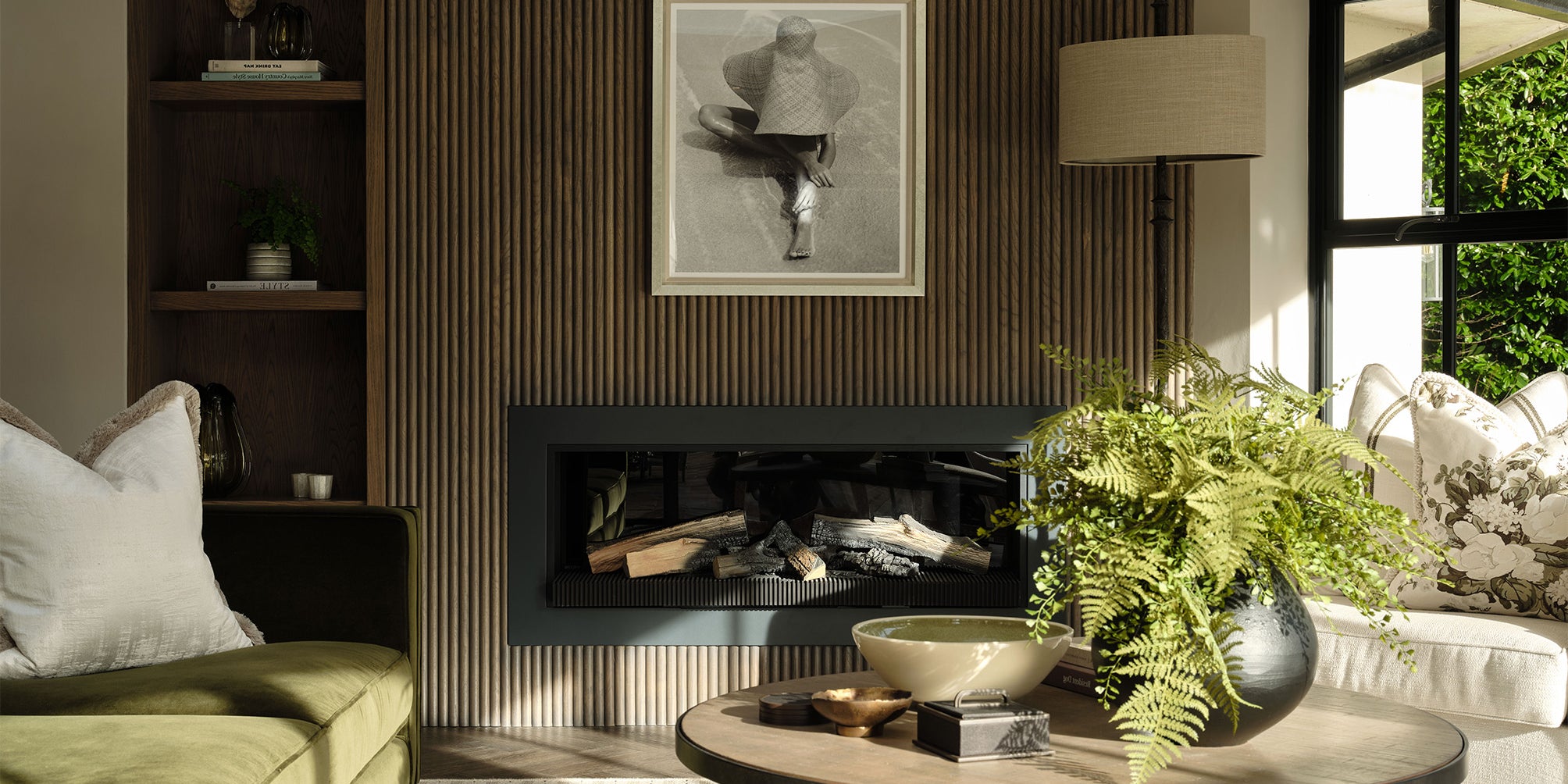 Living room with a fireplace, sofa, coffee table, and decorative items.