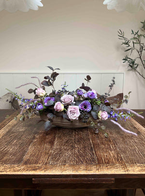 Floral arrangement on a wooden table with a neutral background