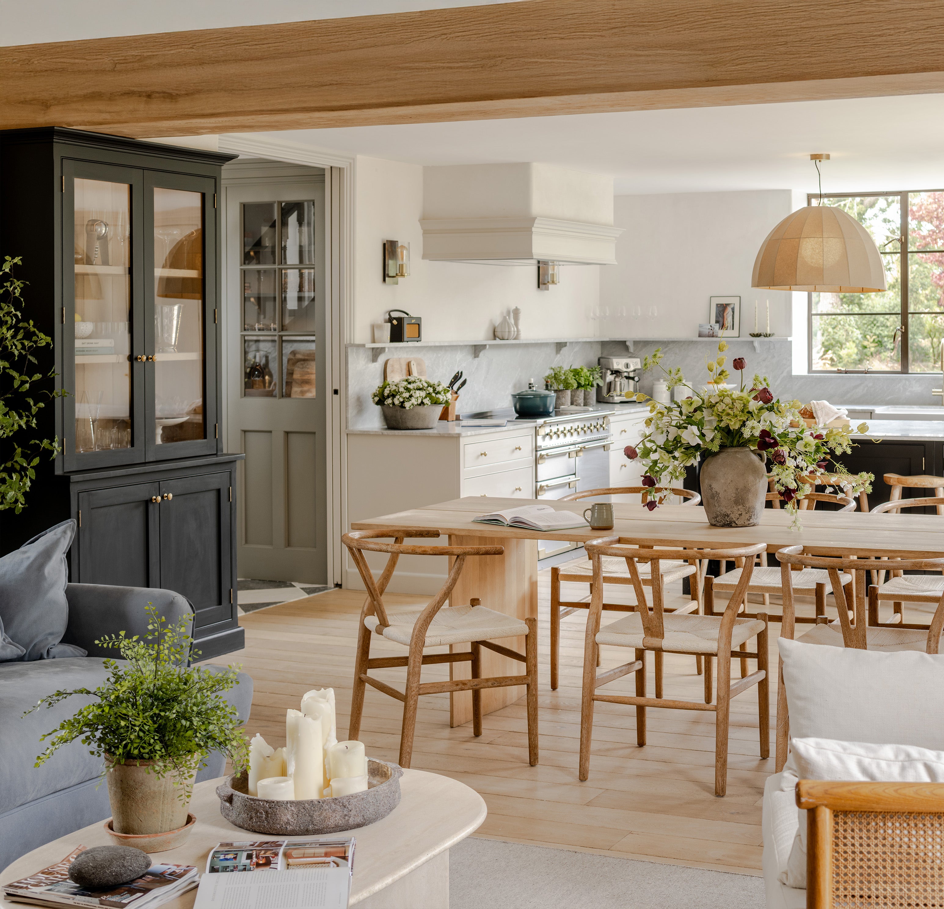 Modern living room with a dining area featuring wooden furniture and decorative elements.