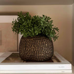 Decorative pot with faux greenery on top of books Rtfact flowers