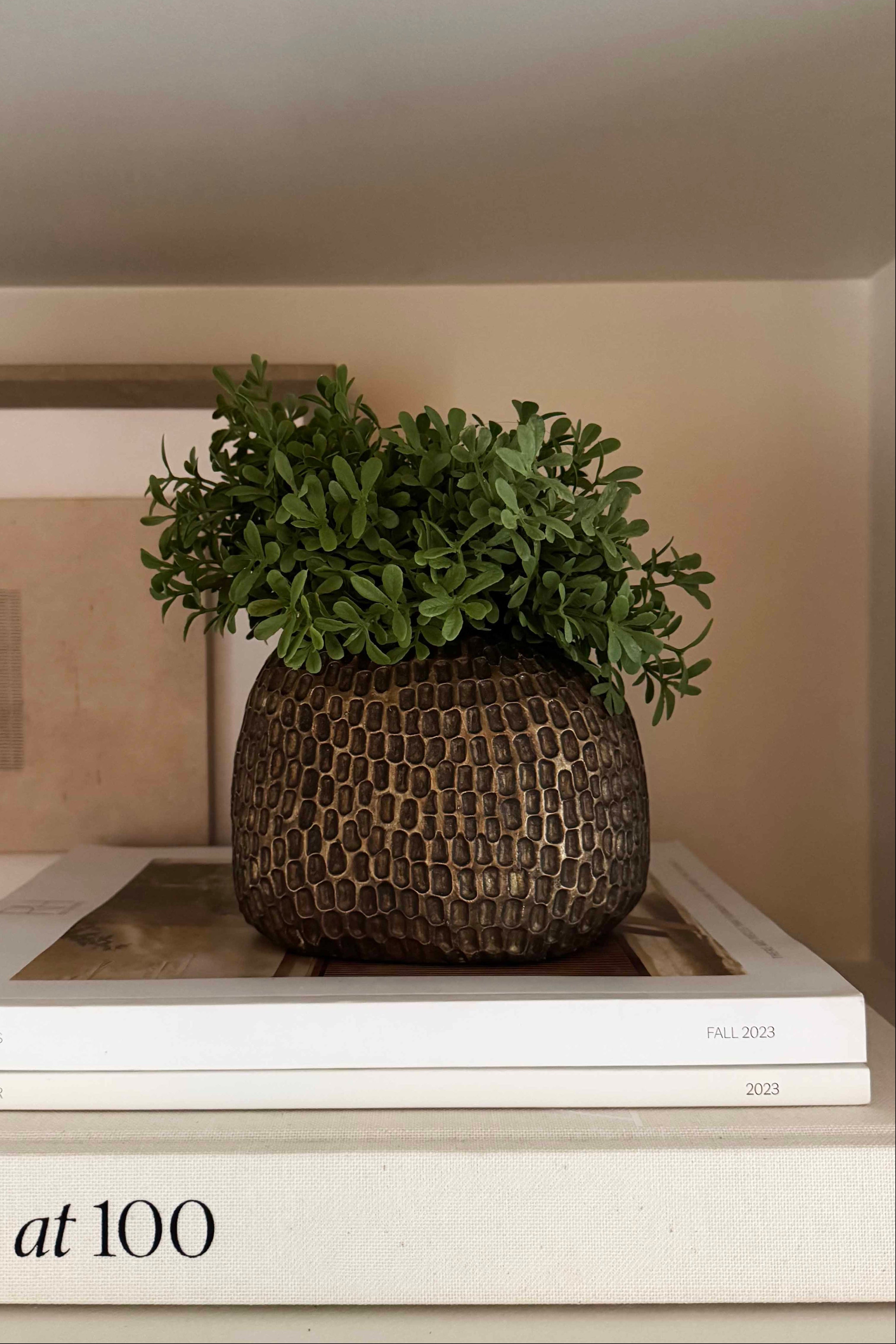 Decorative pot with faux greenery on top of books Rtfact flowers