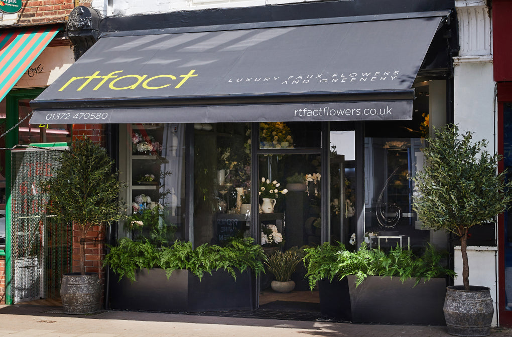 Floral shop entrance with 'rtfact' branding and flower display inside.