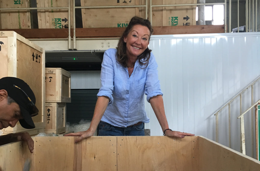 Woman standing behind a wooden crate in a warehouse setting