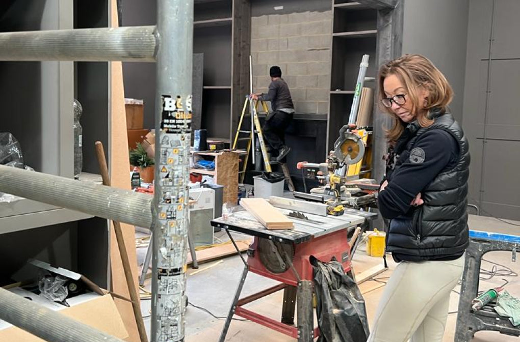 Person standing in a workshop with tools and materials around
