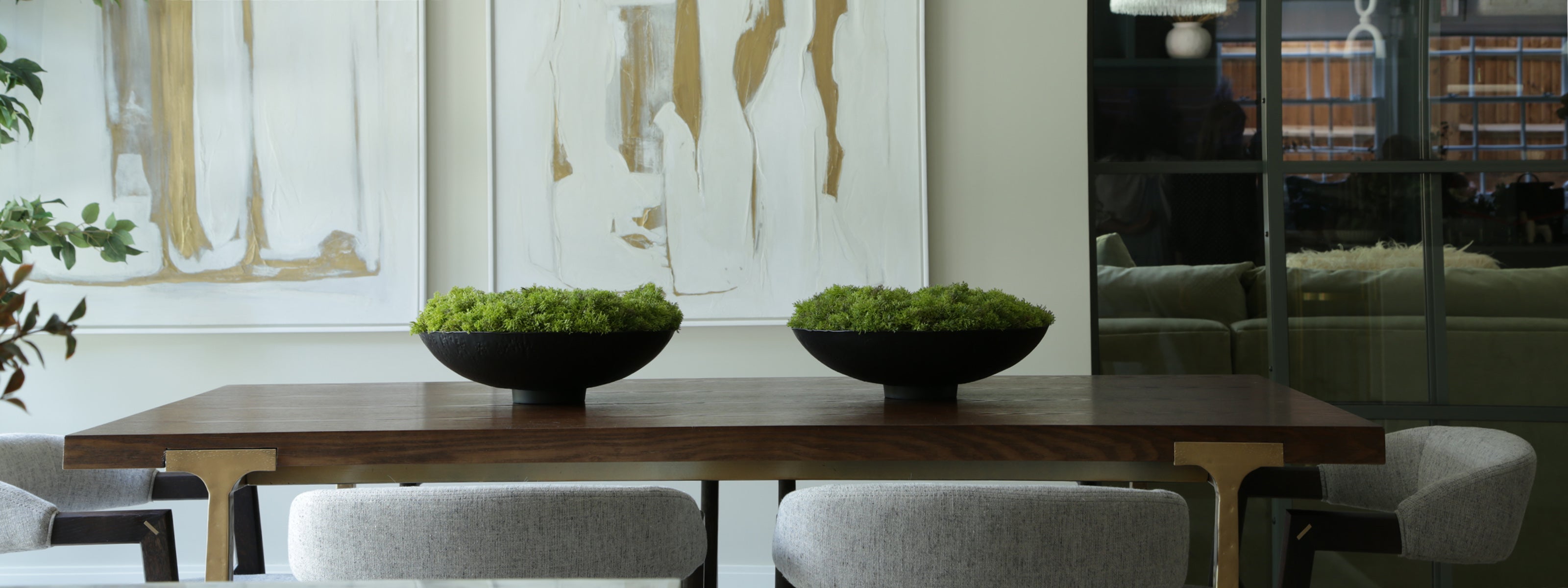 Dining table with two decorative bowls and chairs in a modern interior setting.